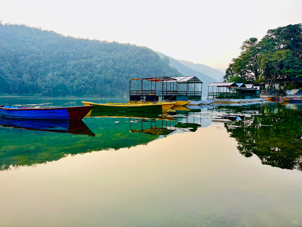 Boats and reflections on Phewa Lake, Pokhara, Nepal.