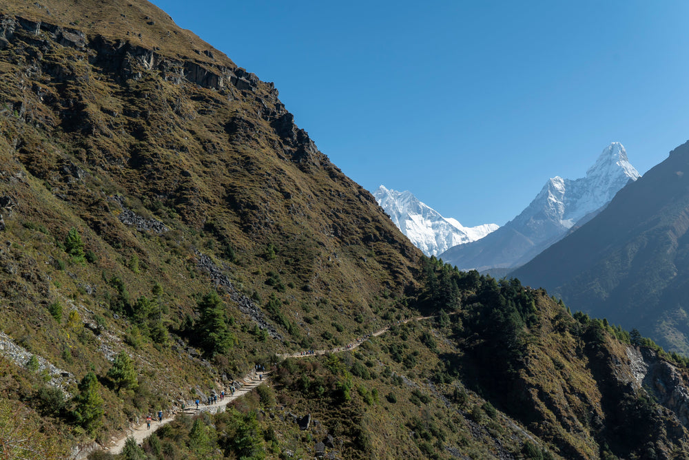 The trail to Everest Base Camp along a steep hillside, with Everest and Ama Dablam ahead, in the Khumbu, Nepal