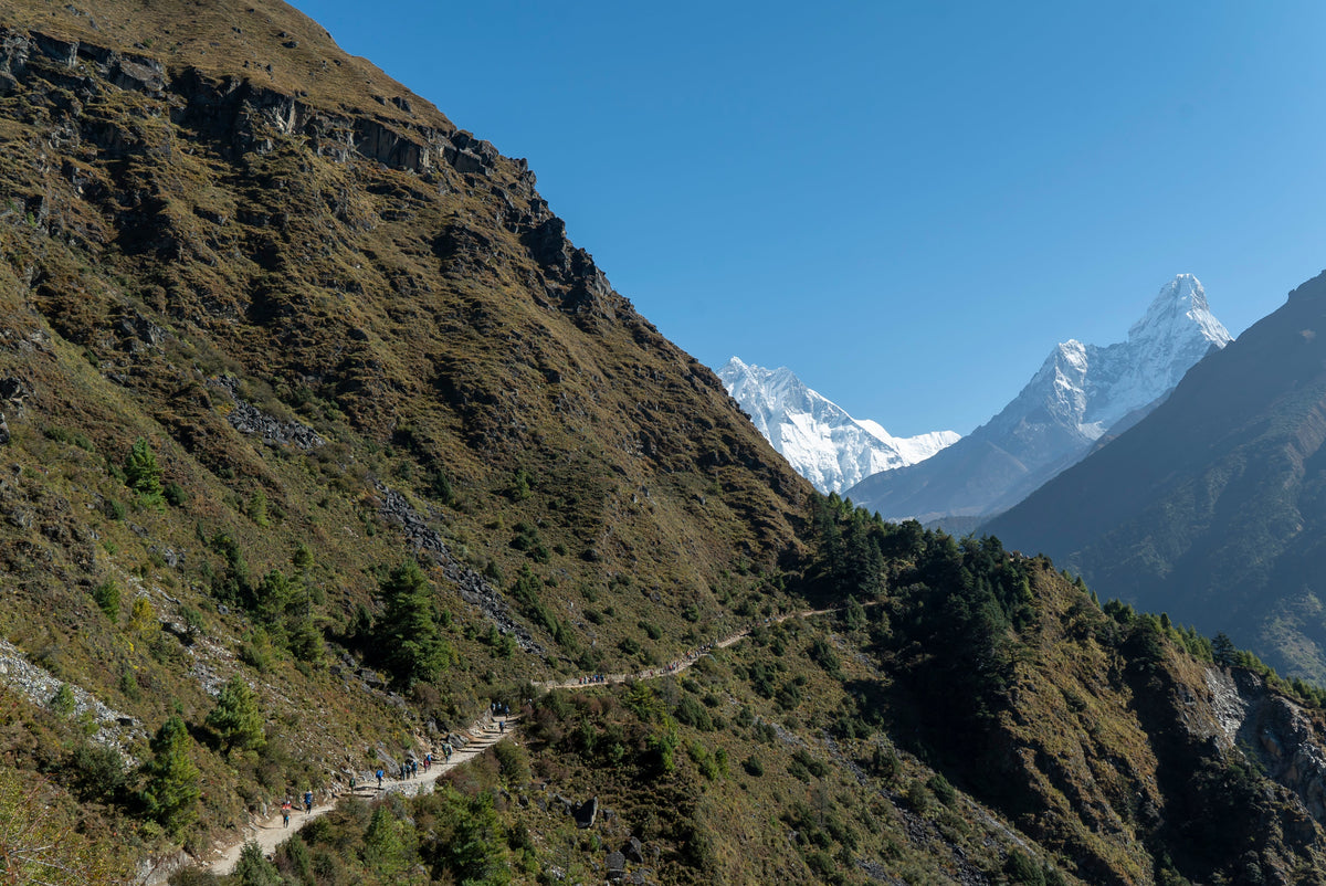 The trail to Everest Base Camp along a steep hillside, with Everest and Ama Dablam ahead, in the Khumbu, Nepal