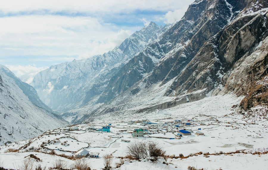 A village on the snowy floor of the Langtang valley, below steep Himalayan peaks
