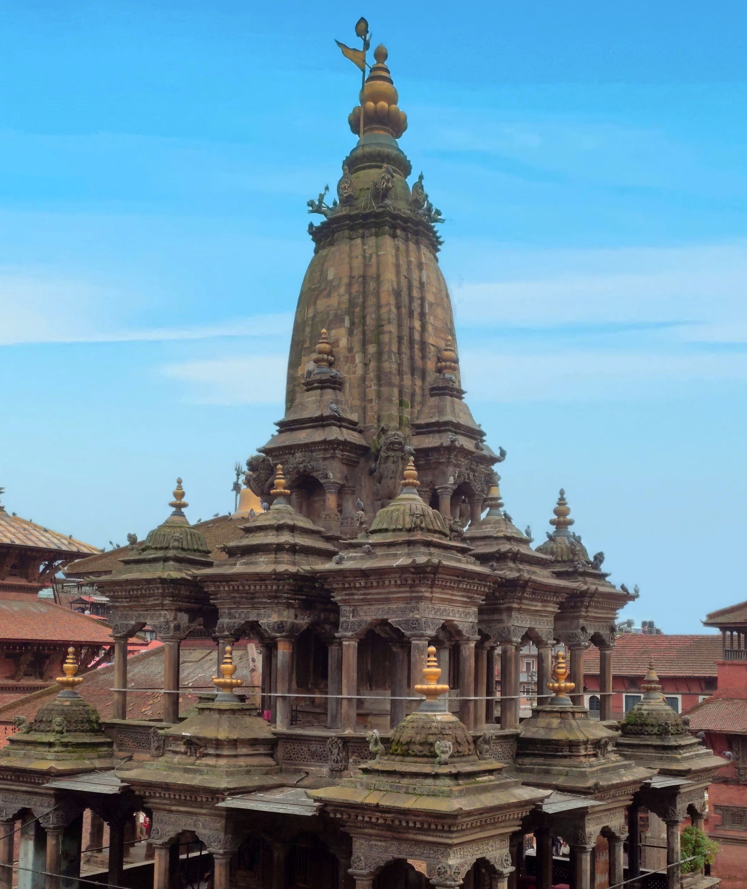 Traditional Nepalese temple with intricate architecture against a clear blue sky.