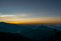 Silhouette of mountains with a sunset or sunrise in the background
