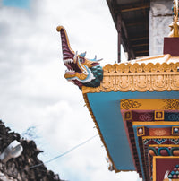 Decorative dragon sculpture on a traditional building with a cloudy sky background