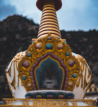 Decorative stupa with intricate designs against a natural background
