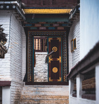 Decorative wooden door with intricate patterns in a stone-walled building