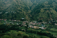 Hillside village nestled in a valley surrounded by green mountains