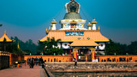 Traditional temple with golden roof and reflective pool at dusk