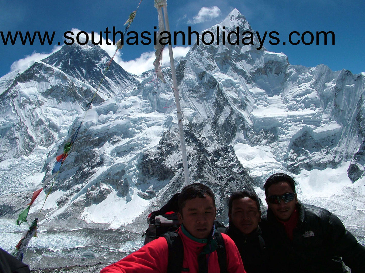 Three South Asian Holidays staff members below Everest and Nuptse, with the company’s web address across the sky