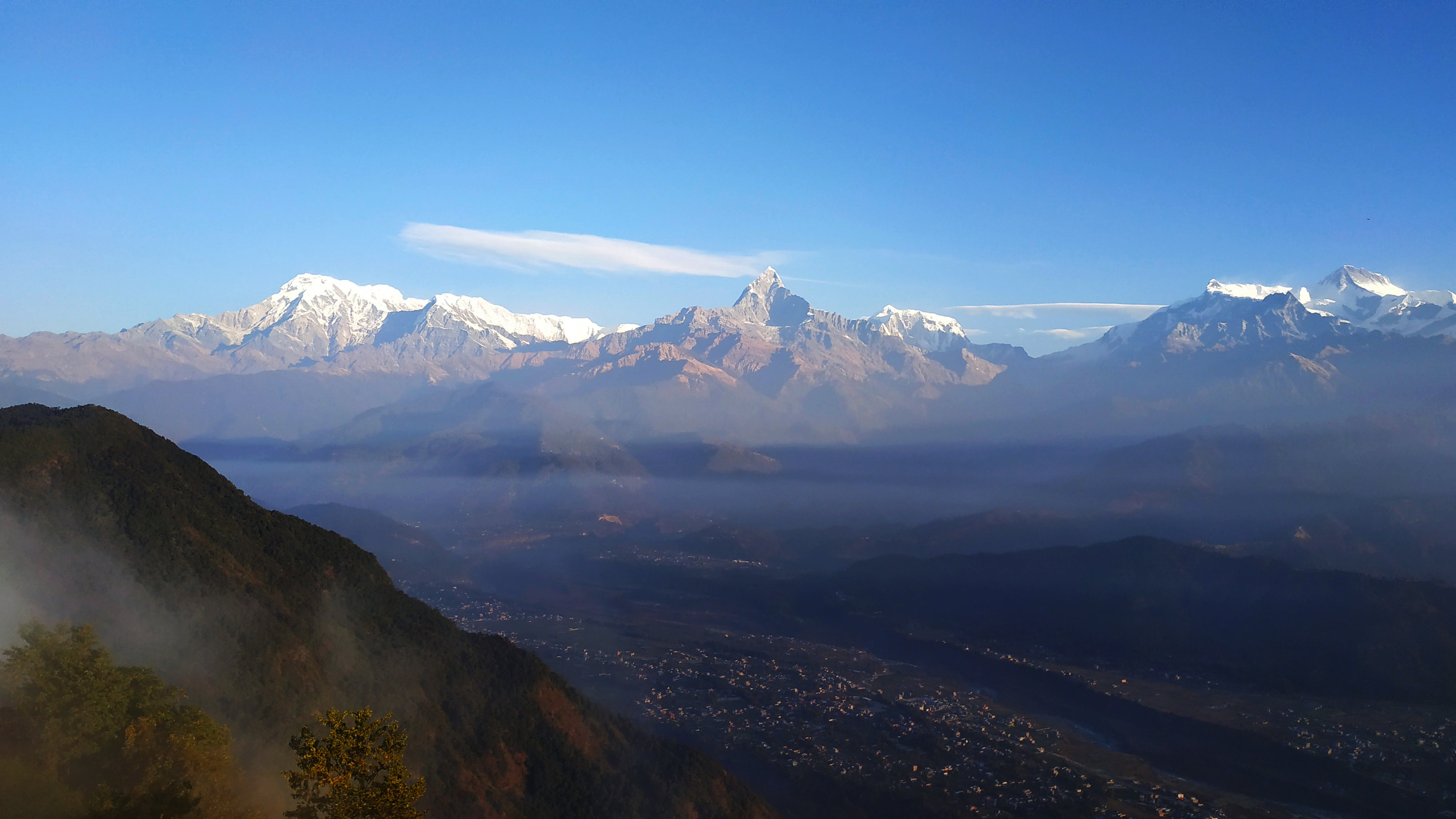 The Annapurna range and Machhapuchhre above the wooded hills at Sarangkot, Pokhara, Nepal