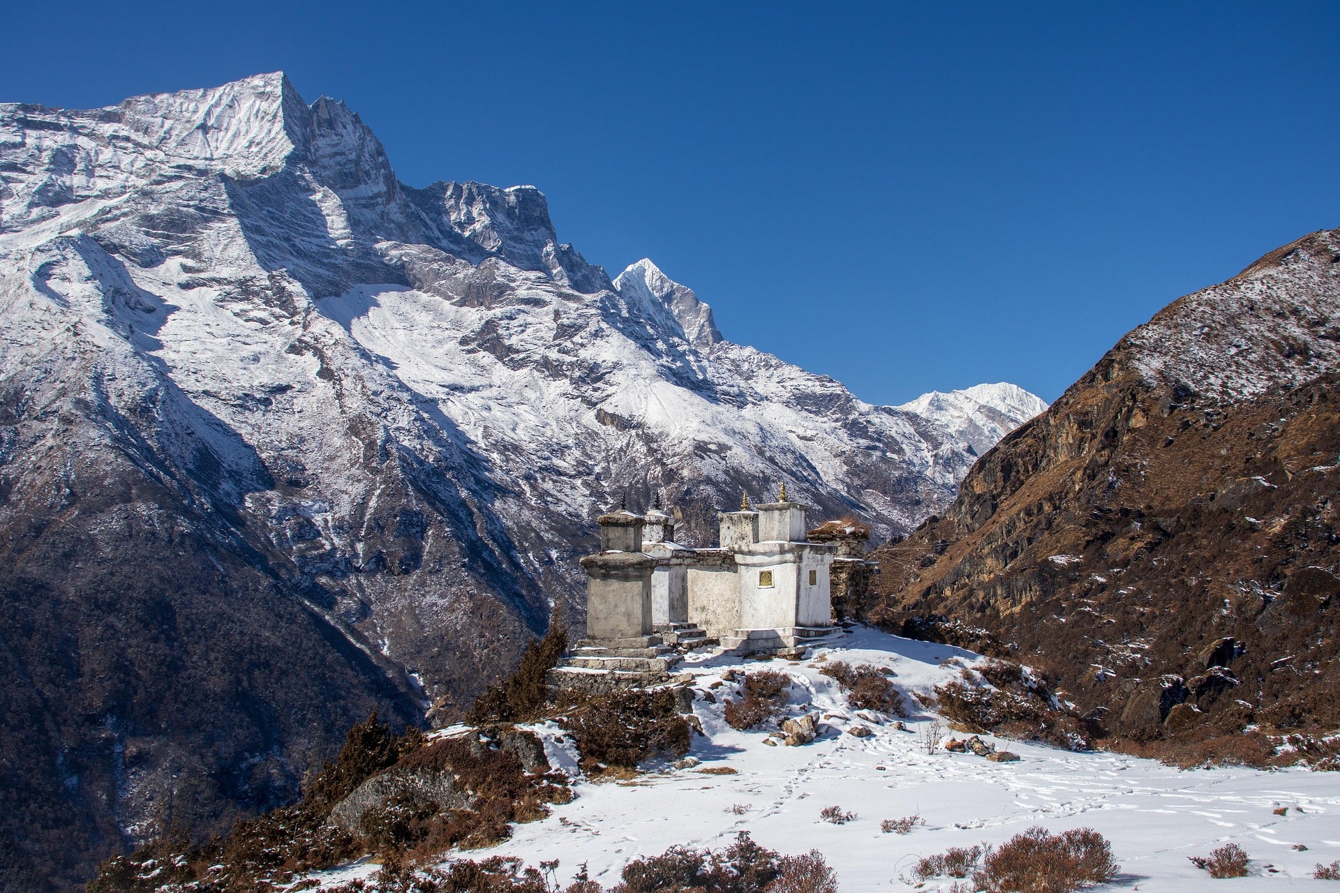 Ancient stone building in a snowy mountain landscape with clear blue sky